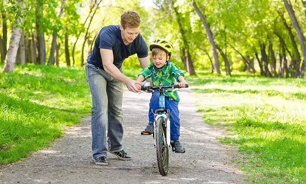 andar com uma criança numa bicicleta de duas rodas